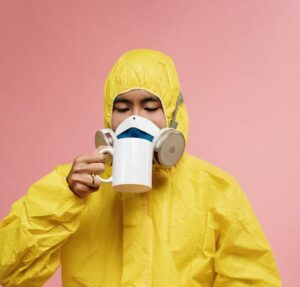 Person In Yellow Protective Suit Drinking